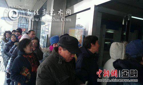 银行门前一早排队等待兑换马年纪念币的市民