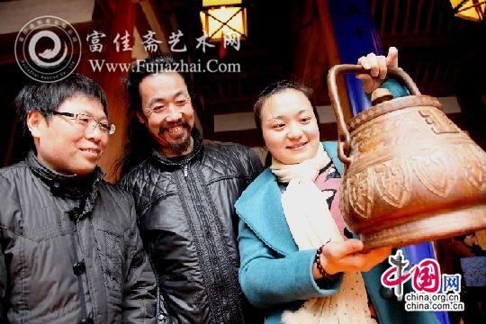 中国网3月35日讯 3月25日，安徽歙县徽州府衙内游客在观赏徽州竹雕大师汪加林（中）的竹雕壶。